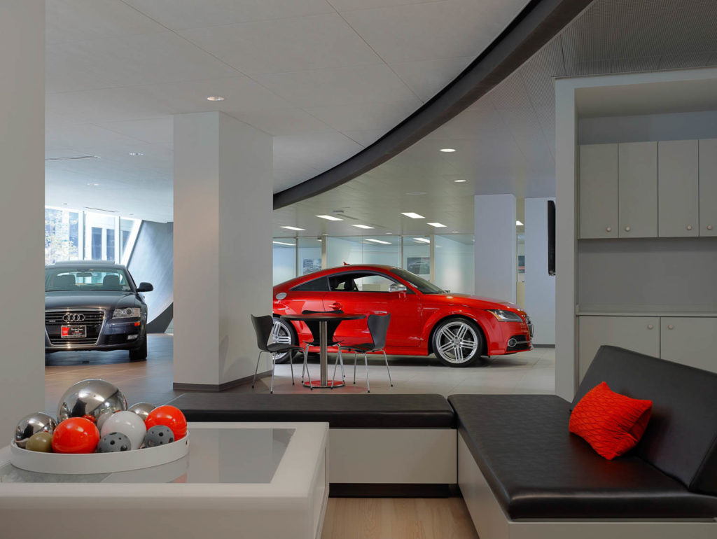 Fletcher Jones Audi by Gensler, showroom with a red Audi TT and lounge seating beneath a curving ceiling, Chicago