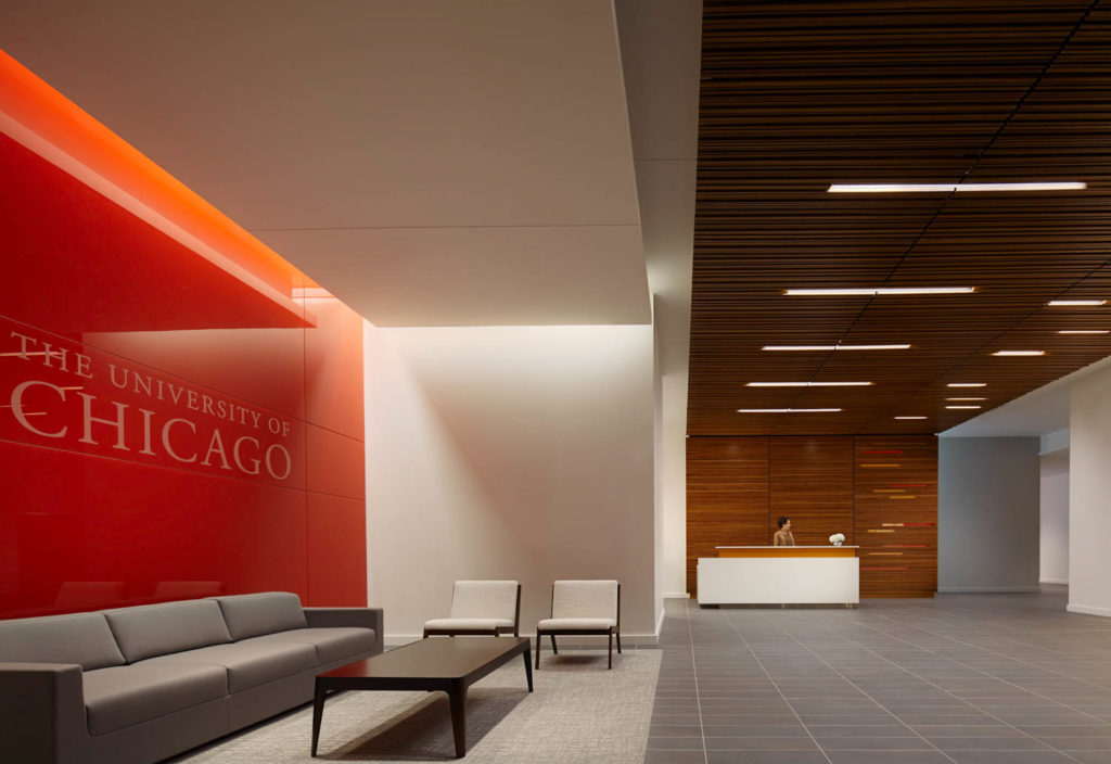 Harper Court by CannonDesign, reception with a red University of Chicago wall and wood ceiling, Chicago