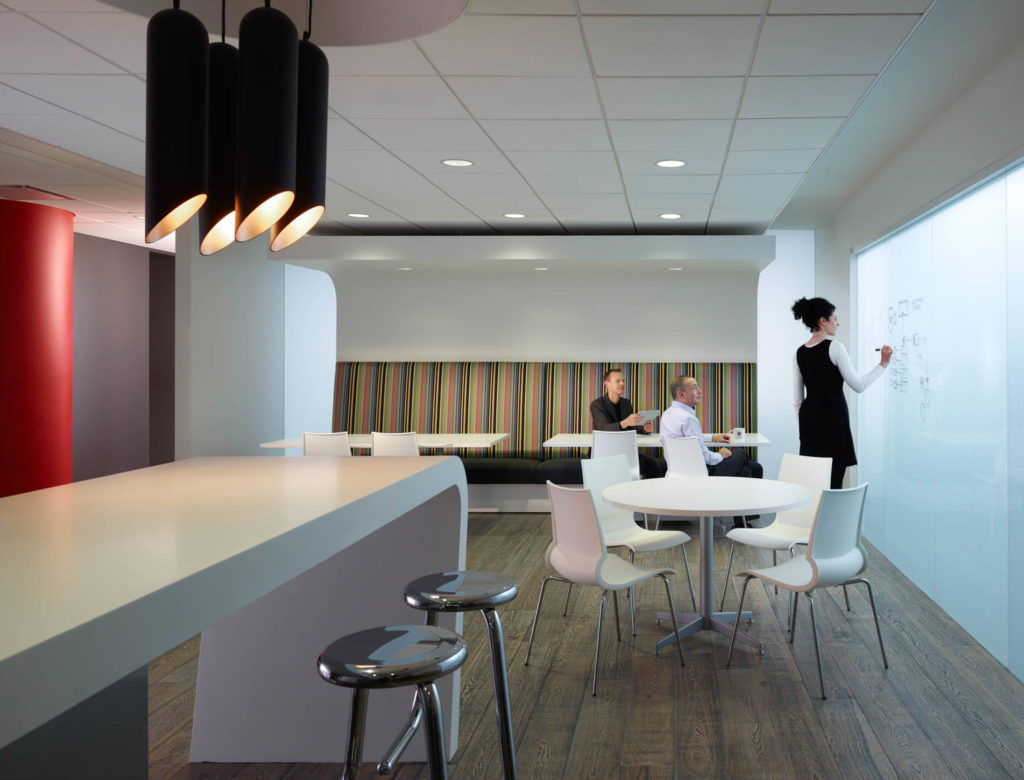 JMC Steel by Gensler, café with a whiteboard wall, striped banquette and black pendant lights, Chicago