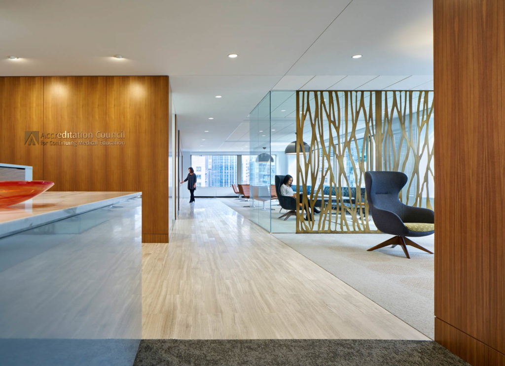 Accreditation Council for Continuing Medical Education by Unispace, reception with a wood wall and a sculptural branch screen, Chicago