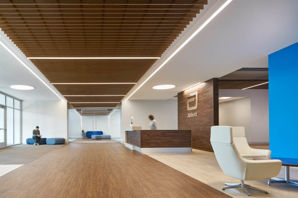 Abbott by Unispace, reception with a wood ceiling and blue accent wall