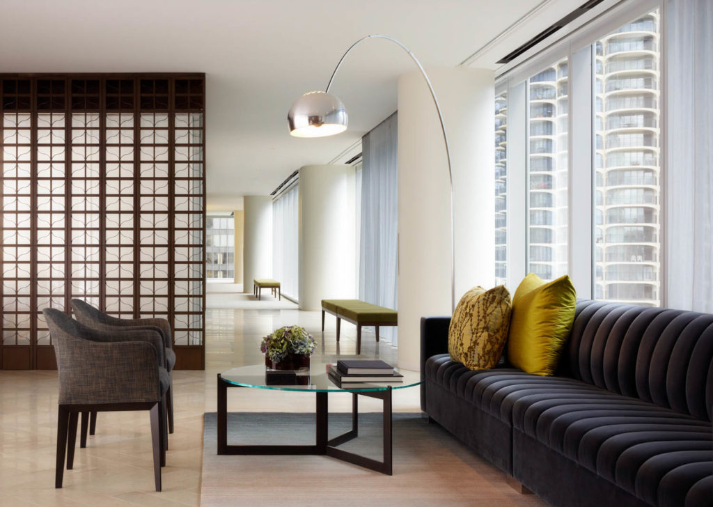 Spencer Stuart by Gensler, lounge with a channel-tufted sofa, arc lamp and city views, Chicago