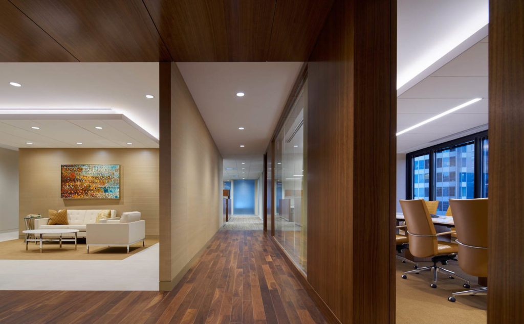 Abbot Downing by TVS Design, corridor with walnut floors between a lounge and conference room