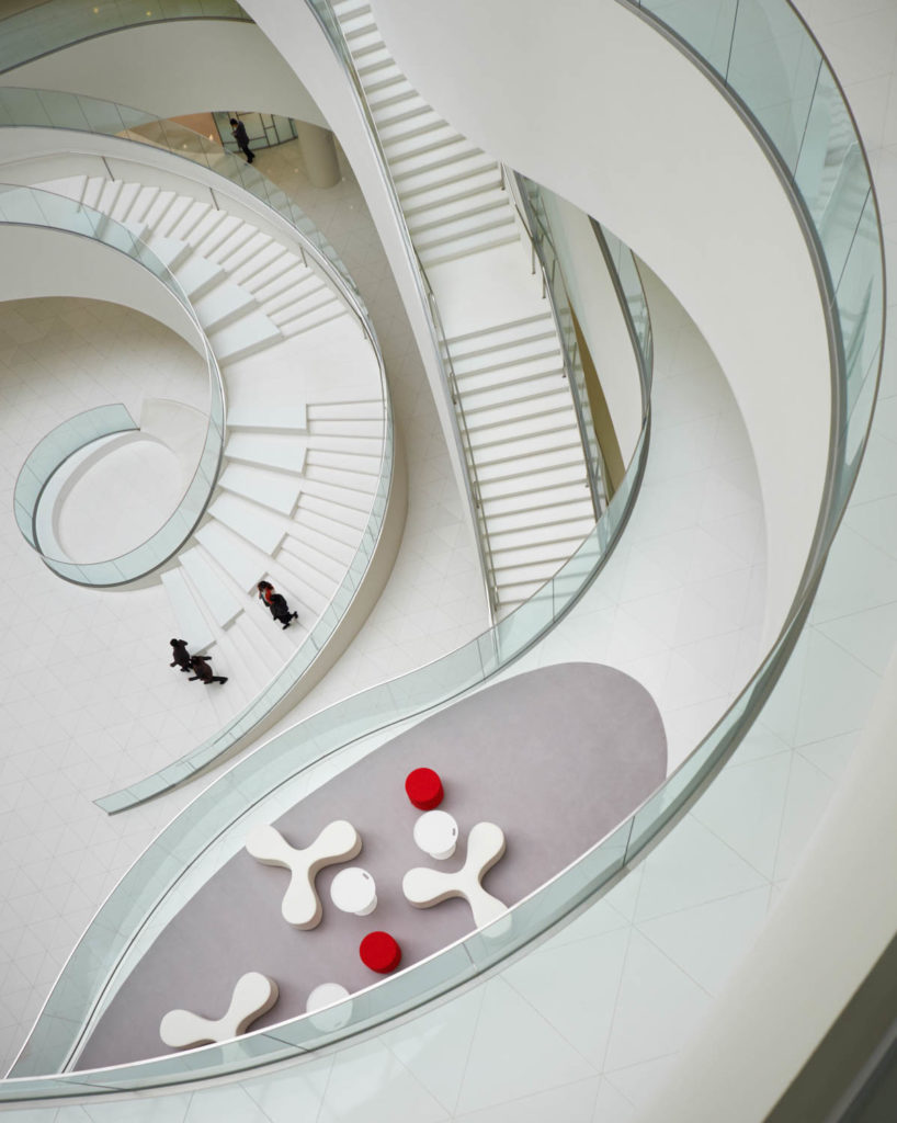 CJ Blossom Park by CannonDesign, view down a spiraling white stair to sculptural seating below, Suwon