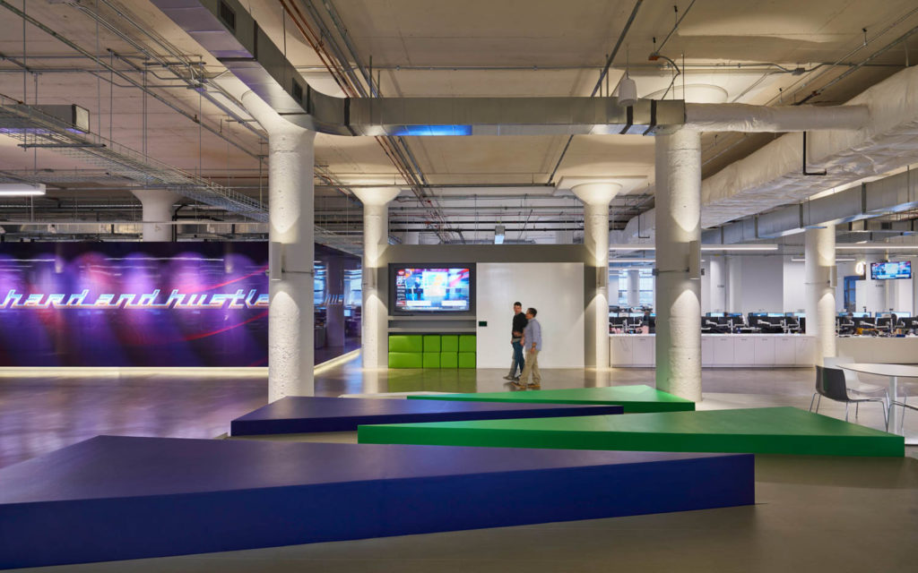 Echo Global Logistics by CannonDesign, open office with colored floor platforms and a neon sign, Chicago