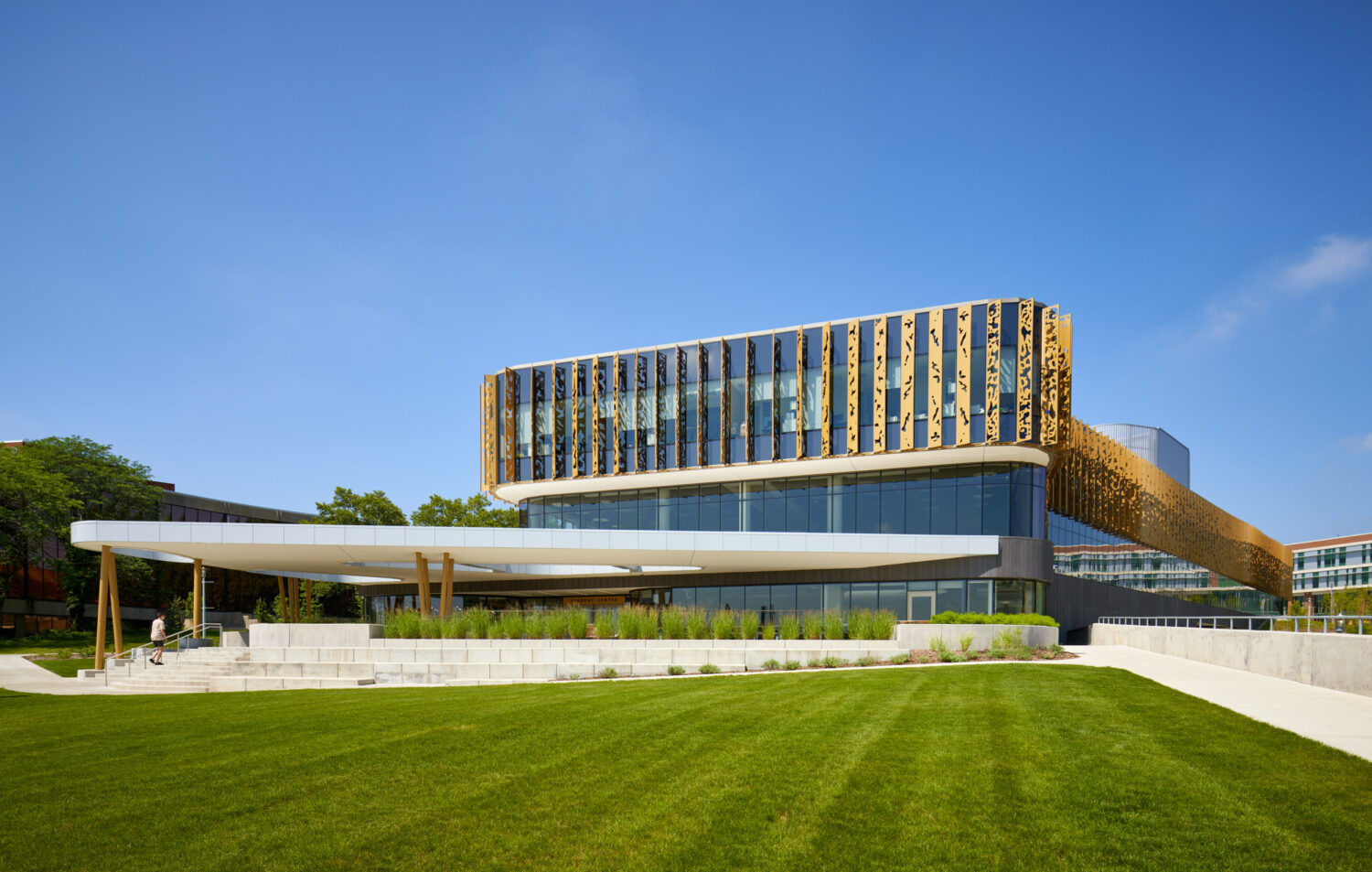 Western Michigan University Student Center across a broad lawn, gold-finned upper floor, white canopy and terraced steps