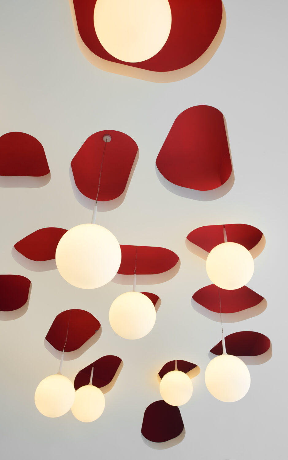 Globe pendant lights hanging among red acoustic ceiling shapes at CJ Blossom Park