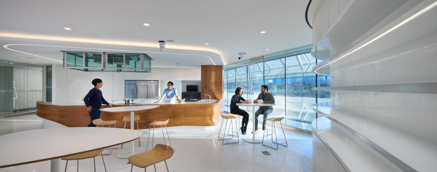 Teaching kitchen at CJ Blossom Park with a curving wood counter, stools and a wall of windows
