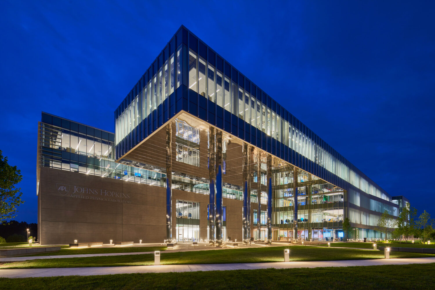 Johns Hopkins Applied Physics Laboratory building by CannonDesign lit at night under a deep blue sky