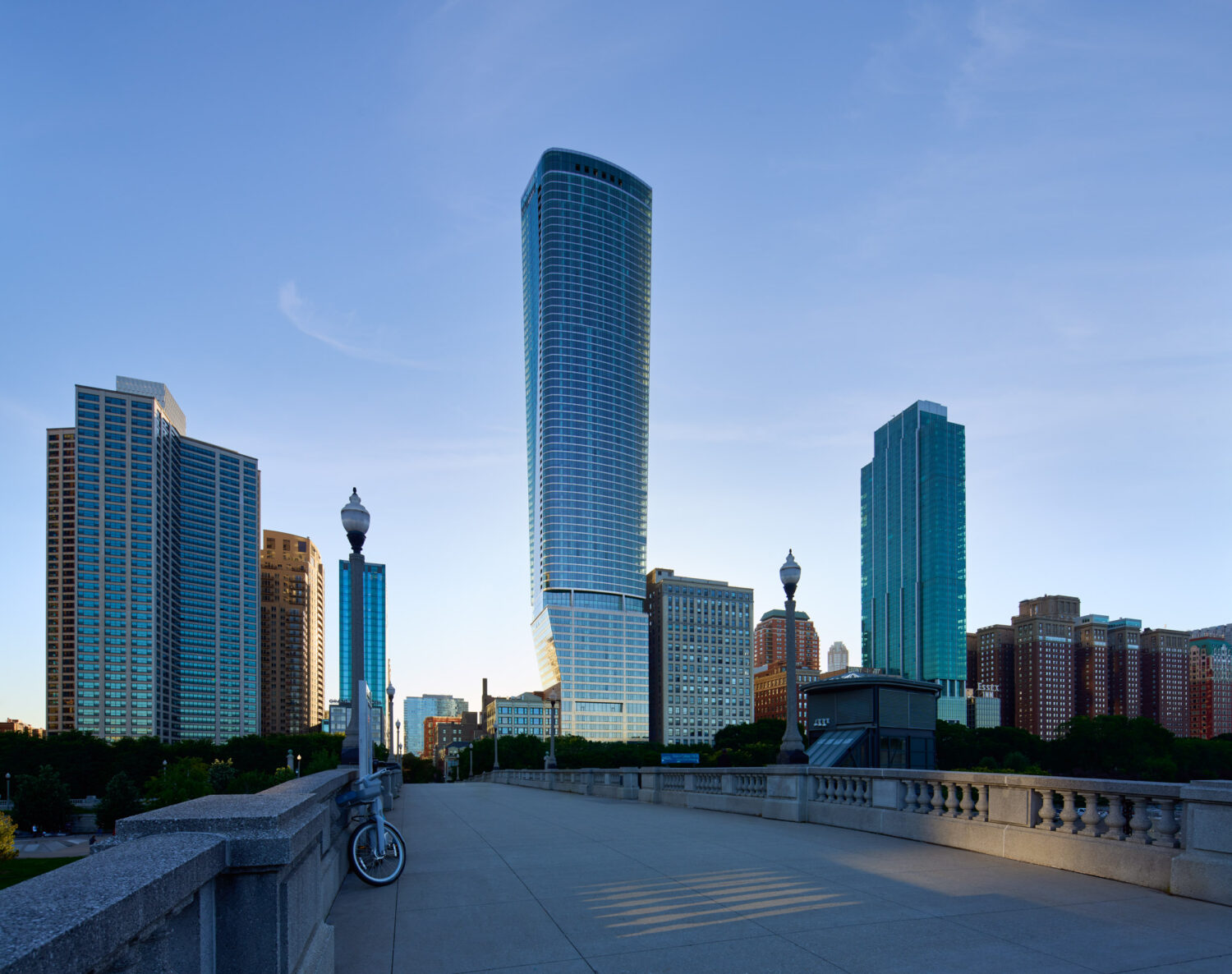 1000M tower by JAHN rising above South Michigan Avenue, seen from a stone bridge, Chicago