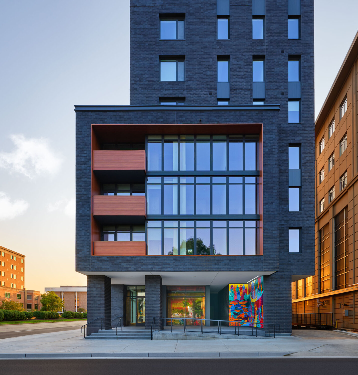 Chapter Madison by Lamar Johnson Collaborative, dark brick residential building with red balconies