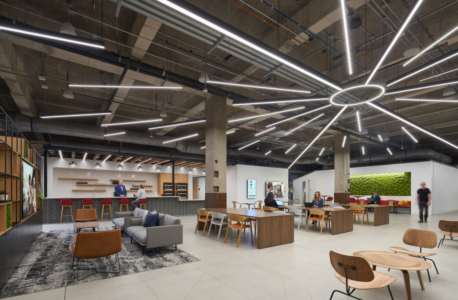 Walgreens Headquarters by Stantec, lounge beneath a starburst light fixture with a moss wall and the Old Post Office concrete columns, Chicago