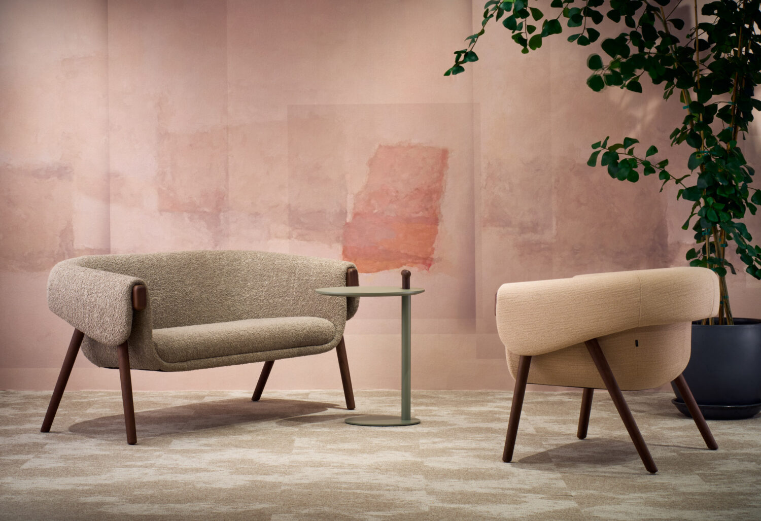 Soft upholstered sofa and lounge chair against a pale pink plaster wall in the Bulo showroom