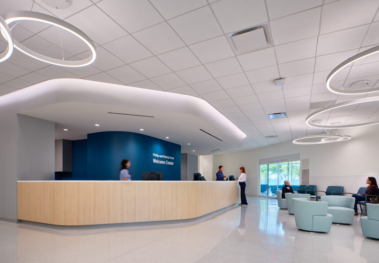 Welcome center reception desk with lounge seating and ring pendants, Braman Comprehensive Cancer Center by CannonDesign, Miami Beach, Florida