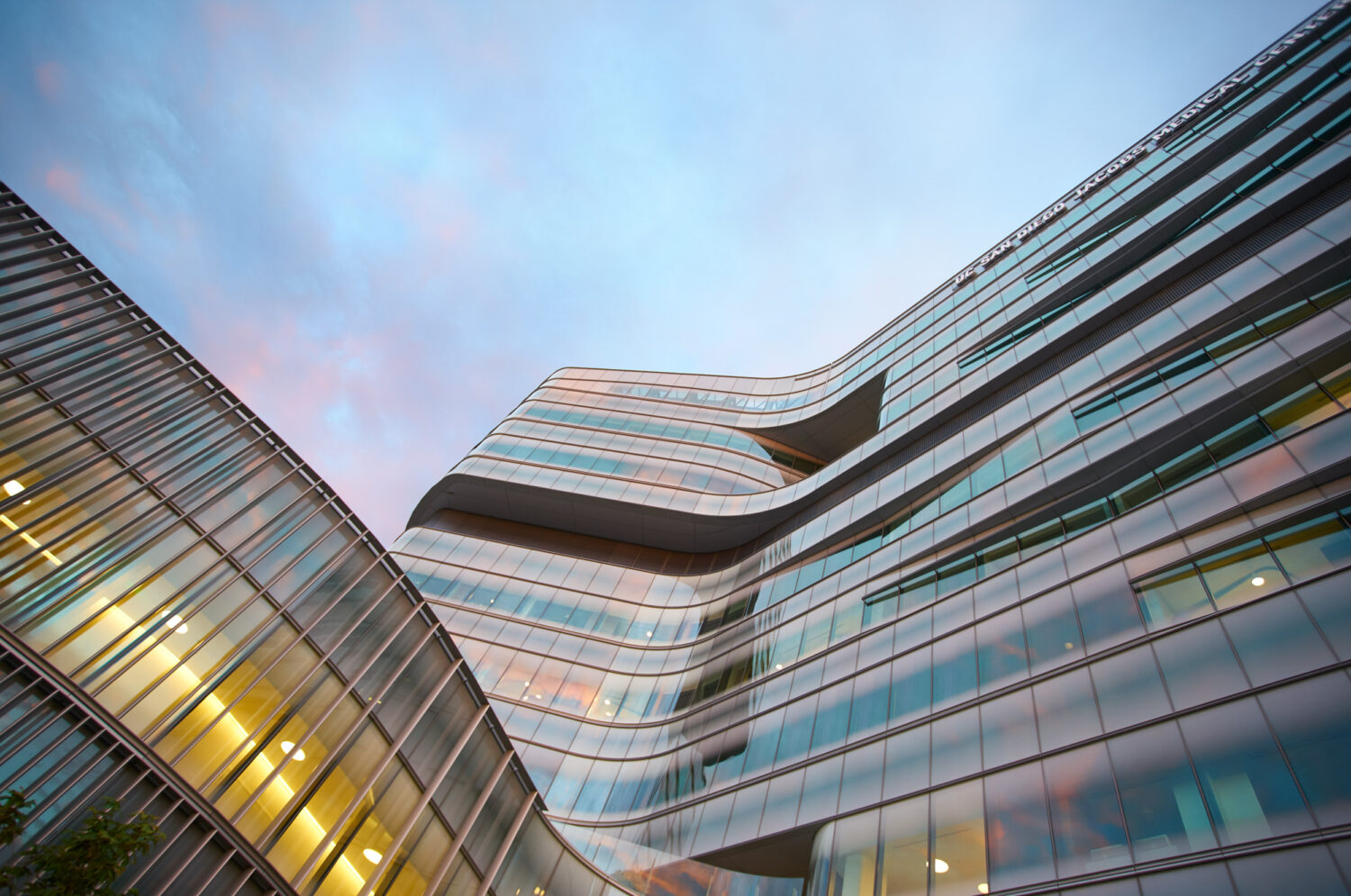 Curving glass facade at dusk seen from below, Jacobs Medical Center, UC San Diego Health by Yazdani Studio of CannonDesign, La Jolla, California