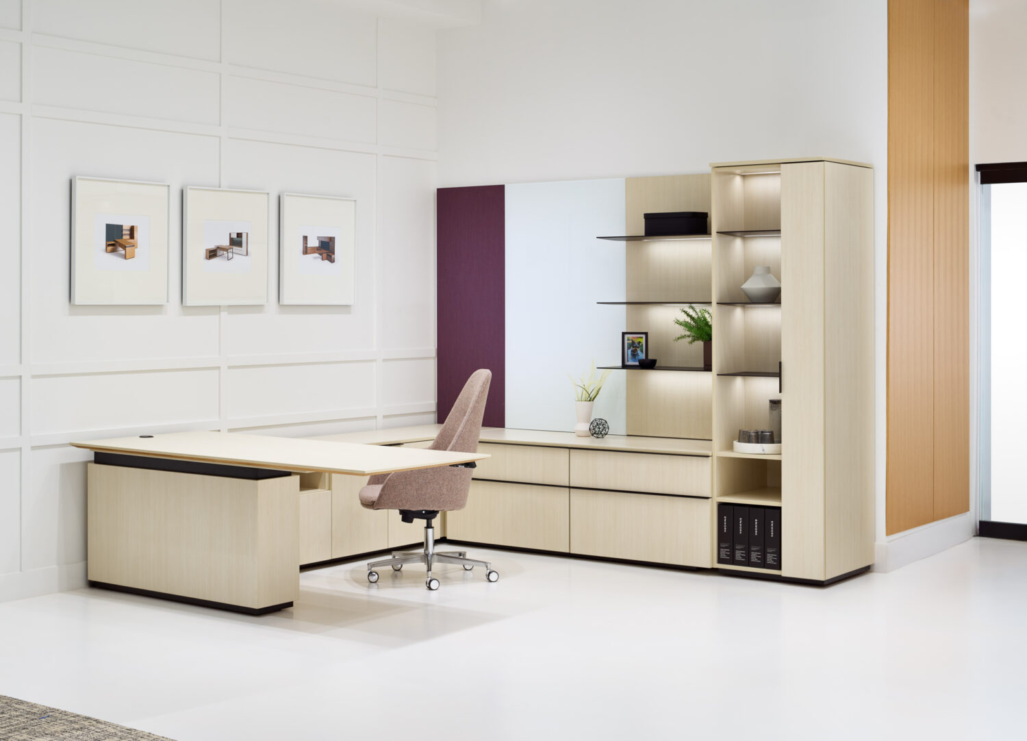 Cream executive desk and lit wood shelving with framed prints in the Enwork showroom