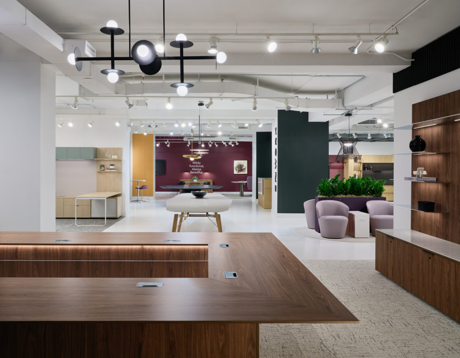 Walnut conference table and sculptural black pendant lights across an open Enwork showroom