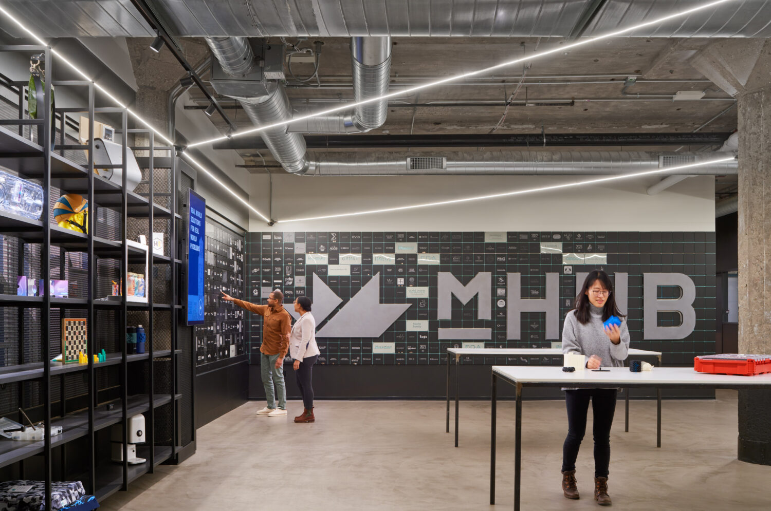 Display shelving for member products in front of the logo wall at mHUB