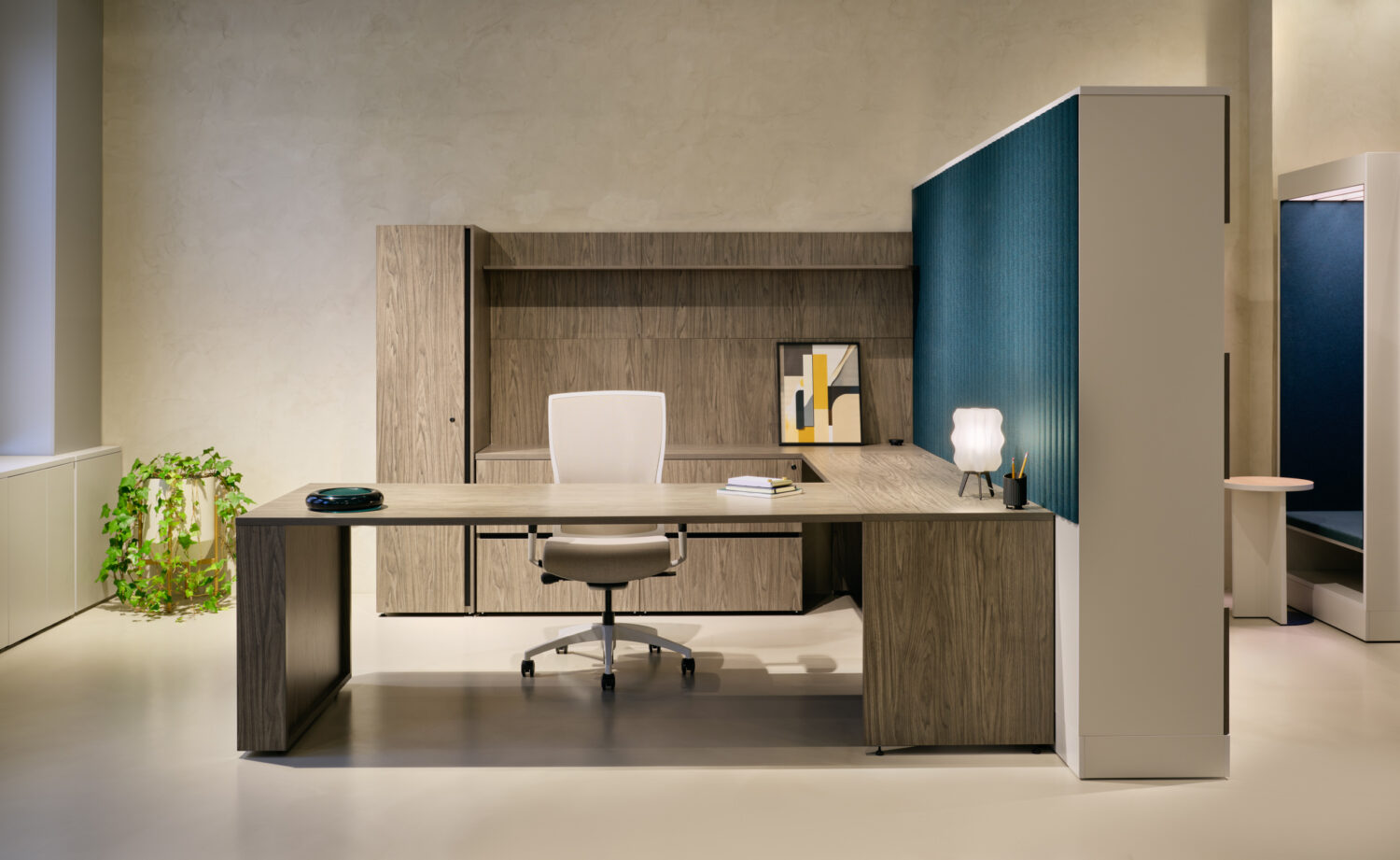 Wood executive desk and storage wall with a teal panel in the Three H showroom