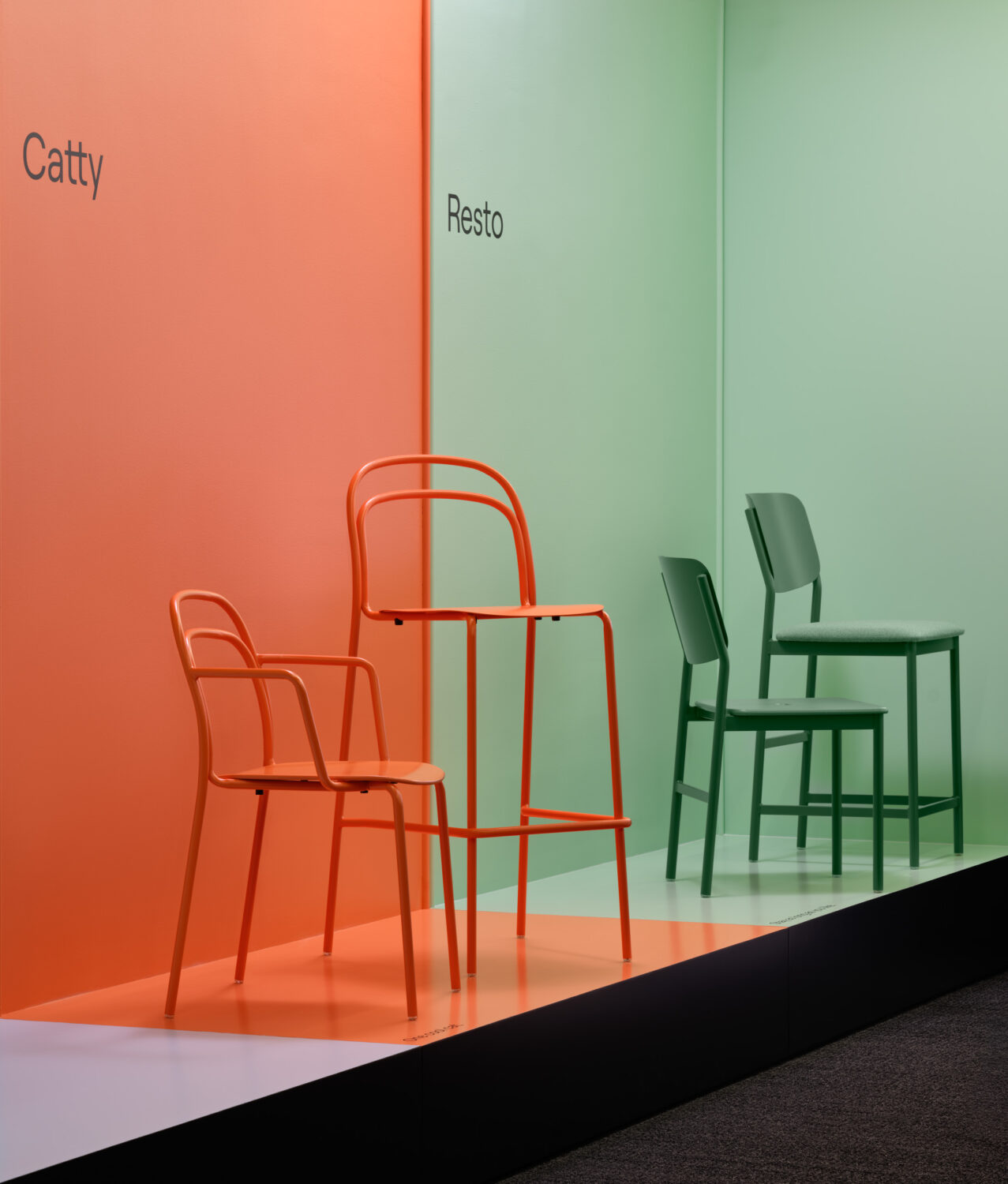 Orange and green metal chairs set against matching orange and green walls in the Keilhauer showroom