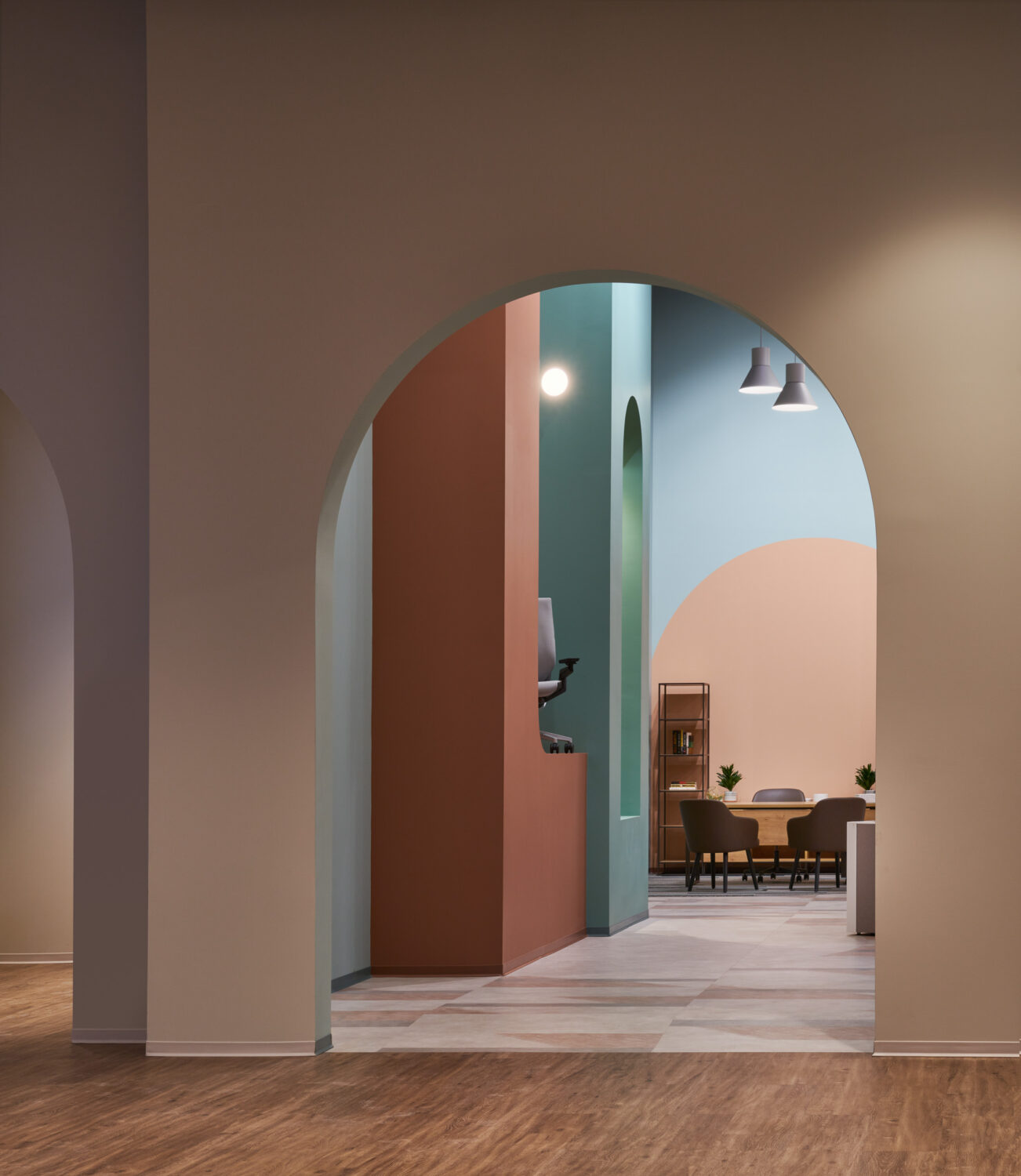 Nested arches in rust, mint and blush leading to a dining area at Forward Space