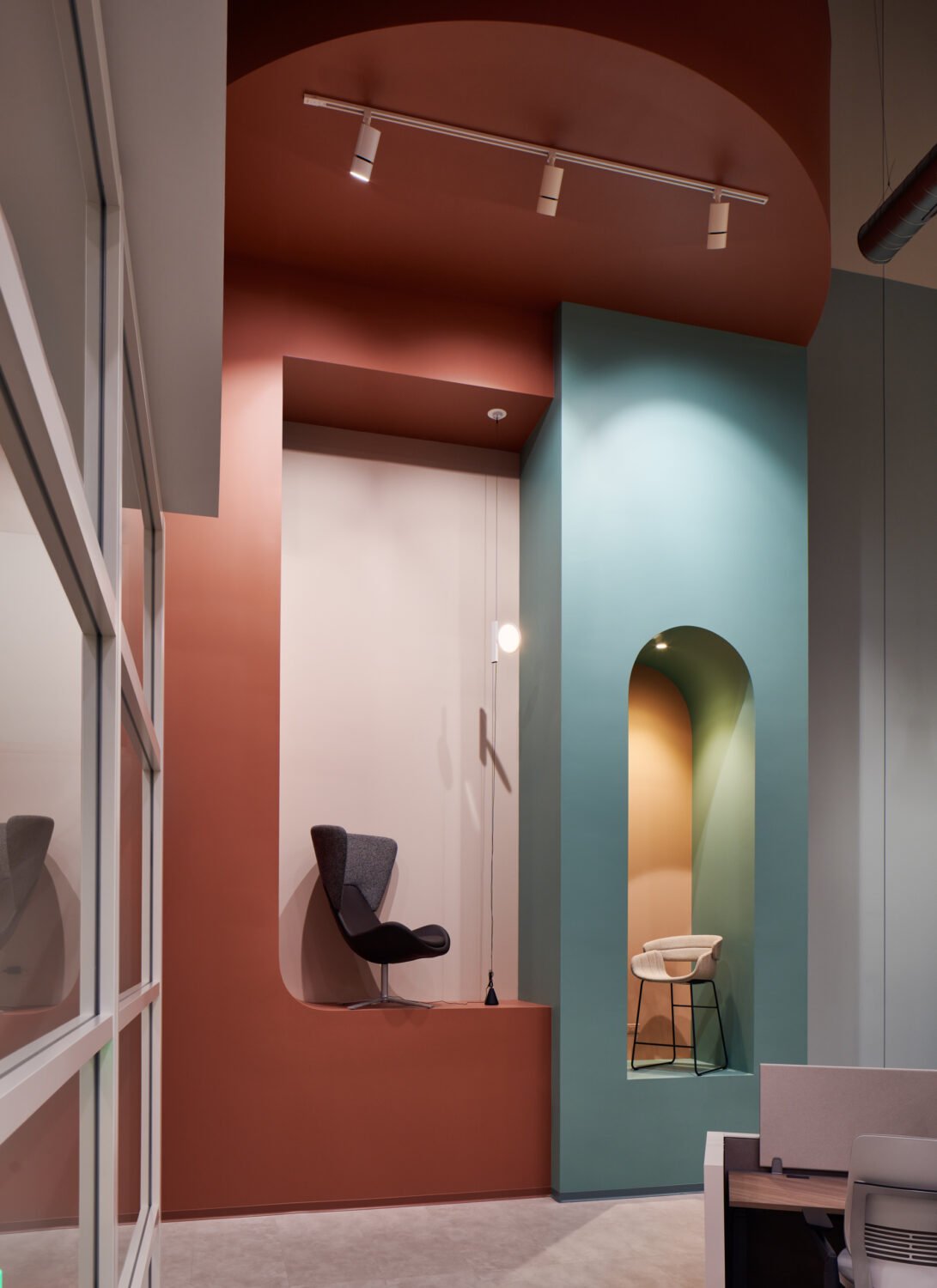 Rust and mint arched niches with lounge chairs at Forward Space