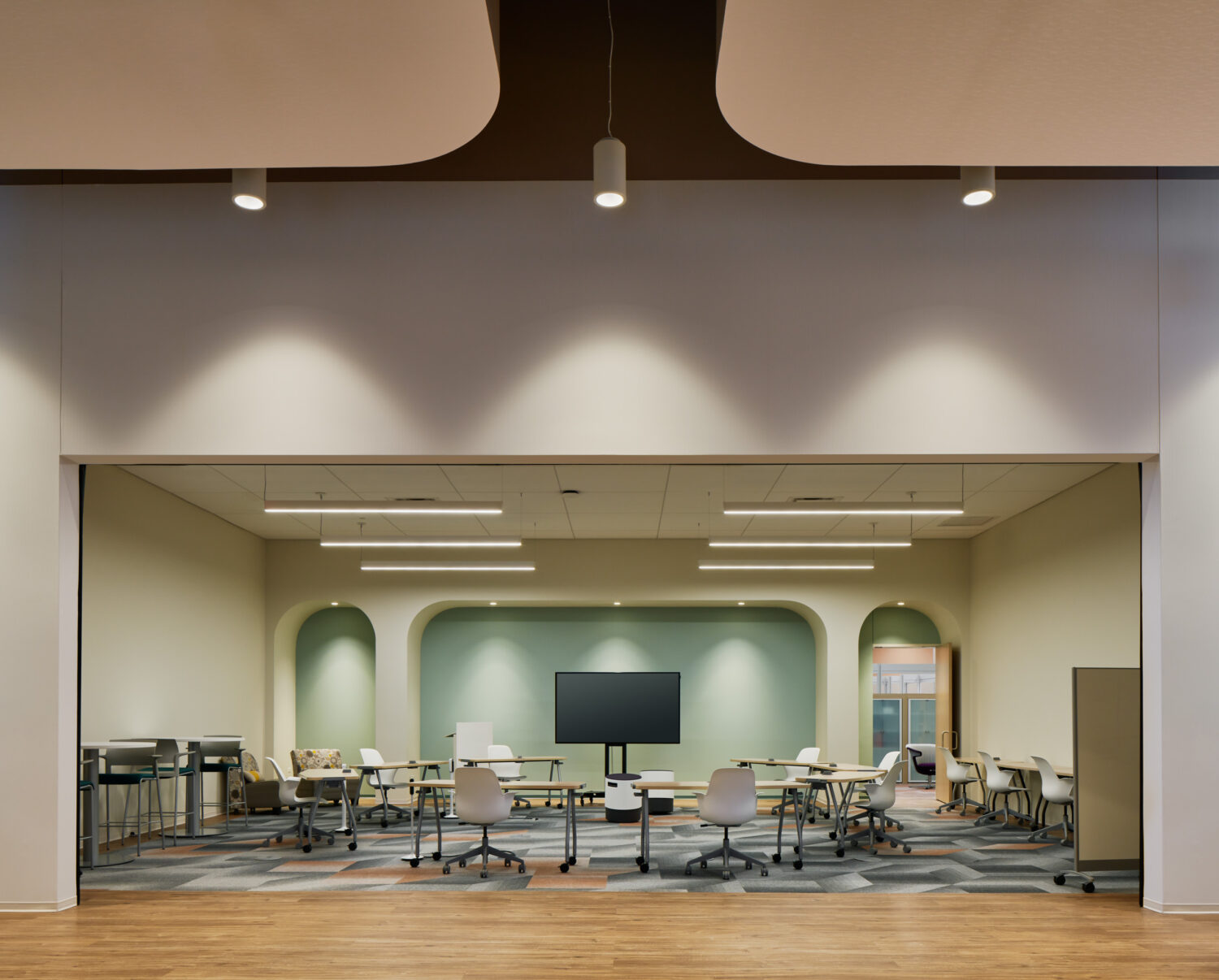 Training room framed by a wide opening with mint arched alcoves at Forward Space