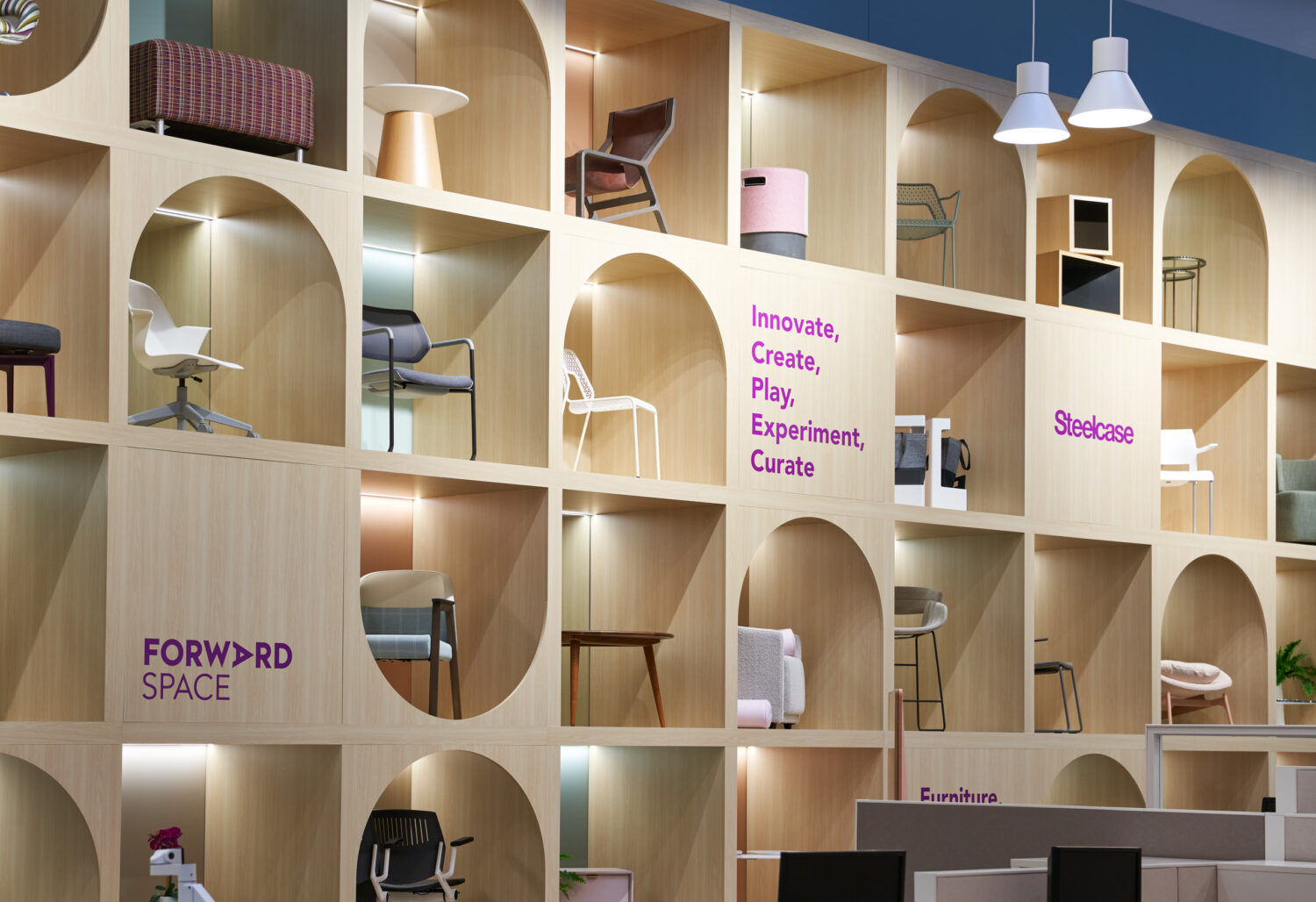 Arched shelving wall displaying chairs with Forward Space and Steelcase graphics