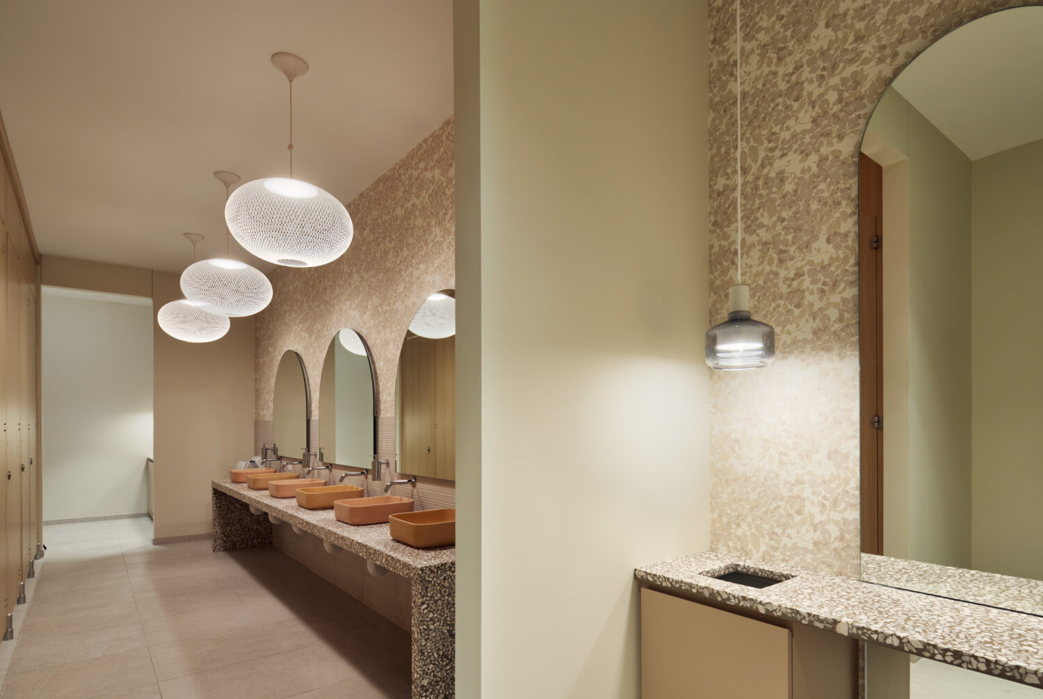 Restroom vanity with copper vessel sinks and globe pendants at Forward Space