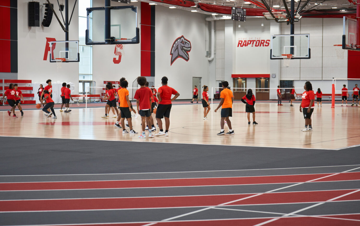 Students playing basketball on a gym court with red RS lettering on the wall at Rich Township High School