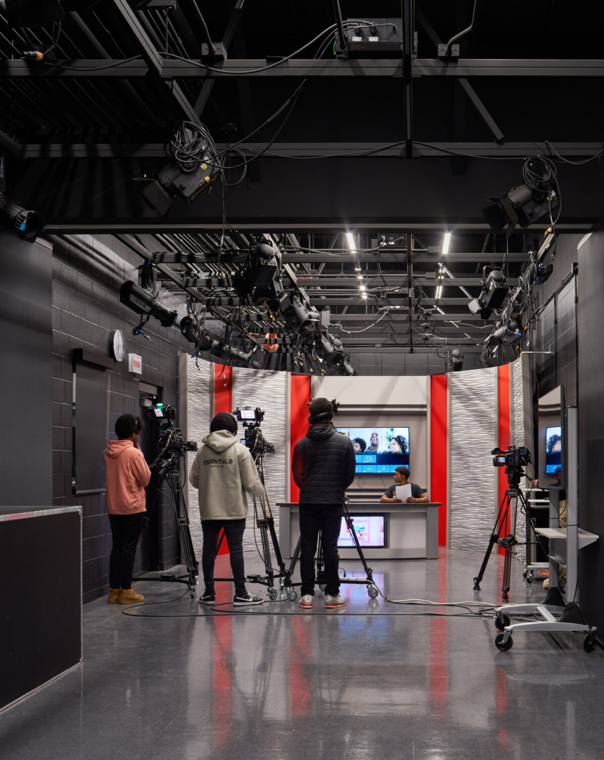 Broadcast studio control room with screens and students at work at Rich Township High School