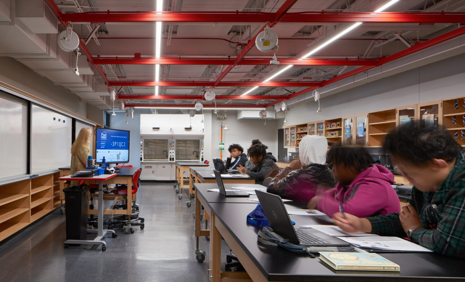 Students working on laptops at lab benches in a bright science classroom at Rich Township High School