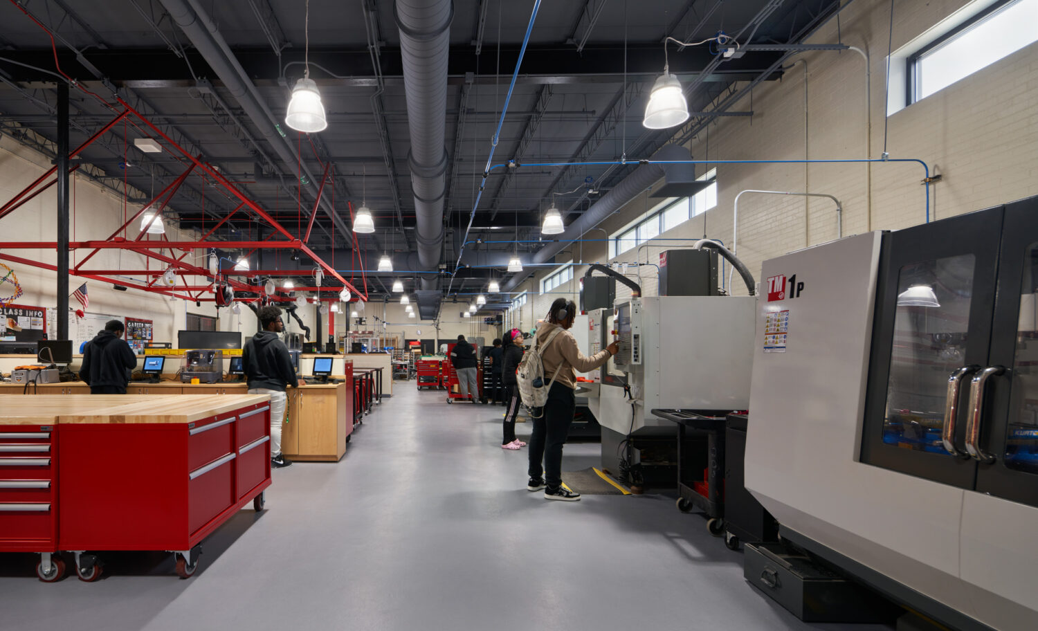 Manufacturing lab with CNC machines, red tool chests and students at work at Rich Township High School