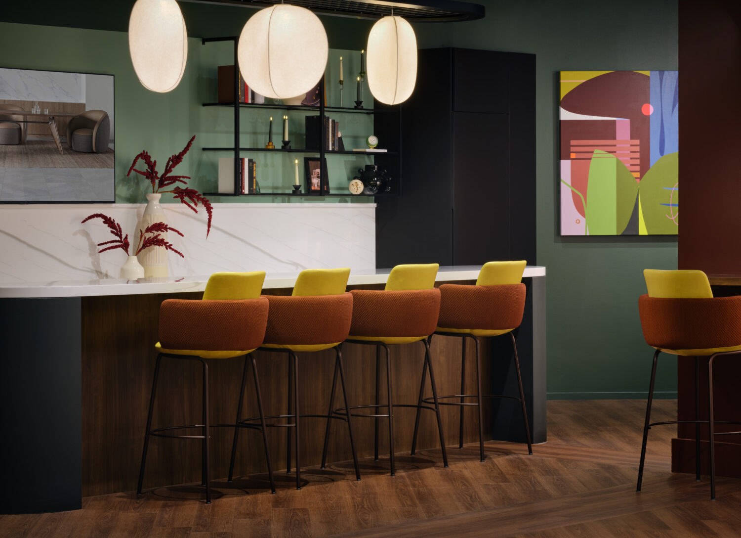 Caramel bar stools along a white counter with lanterns and colorful art in the Source International showroom