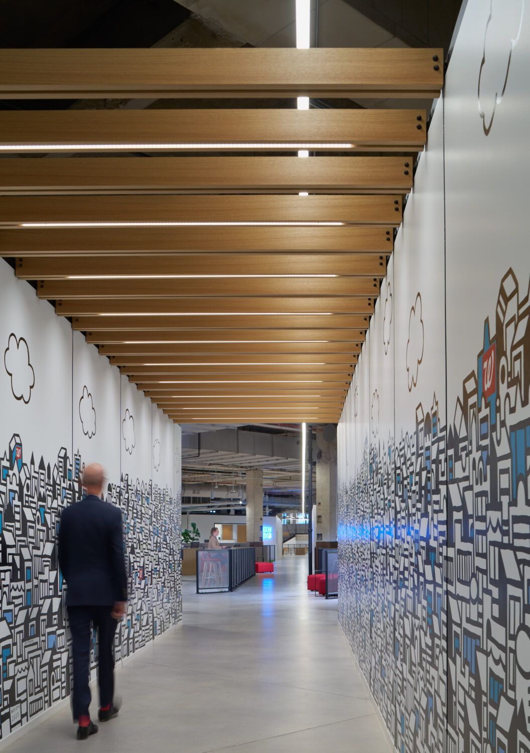 Wood beam corridor lined with hand drawn city murals at Walgreens
