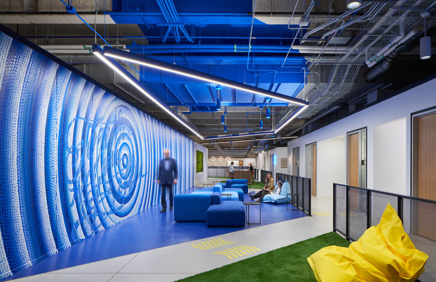 Blue concentric mosaic wall with blue lounge seating and artificial turf at Walgreens