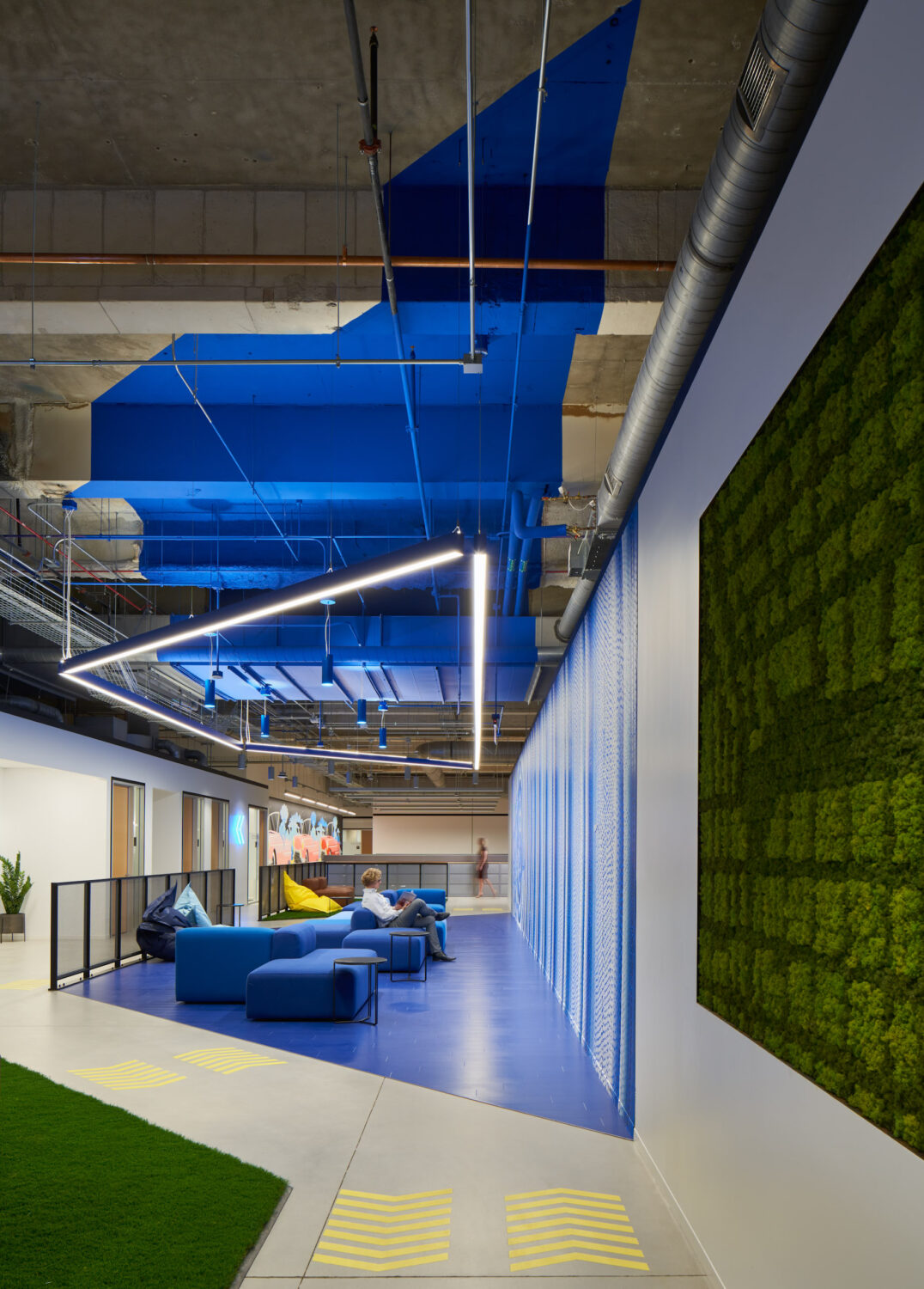 Blue lounge corridor between a moss wall and the mosaic at Walgreens