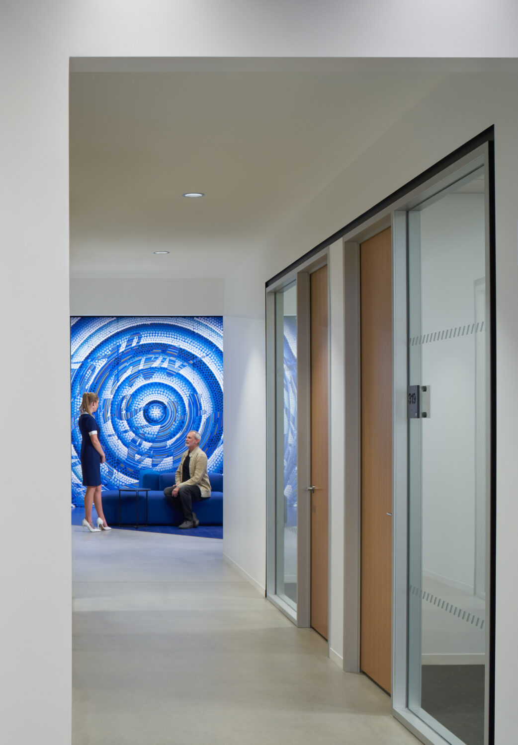 Hallway ending at a blue concentric mosaic alcove at Walgreens