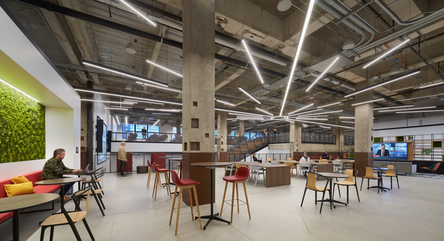 Open work cafe with high tables beneath radiating light lines at Walgreens