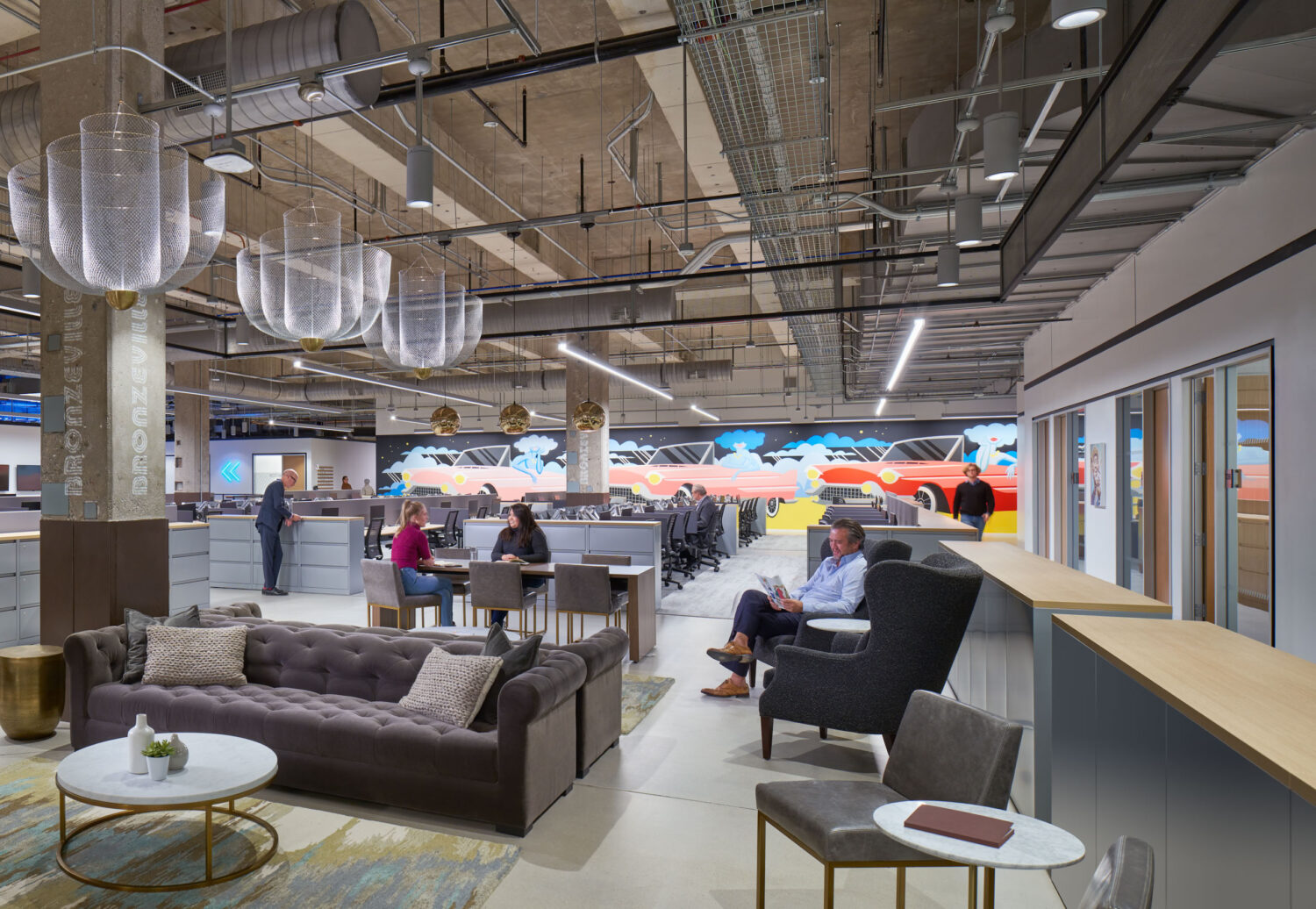 Lounge with tufted sofas and fabric pendant lights in the open office at Walgreens