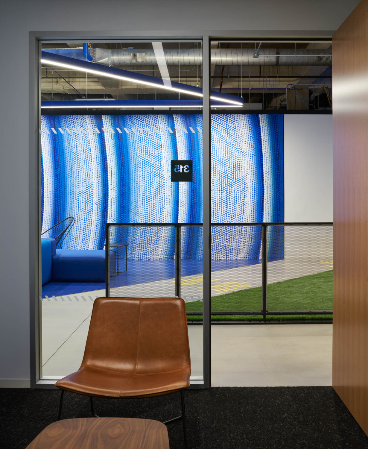 Leather chair in a phone room looking out to the blue mosaic at Walgreens