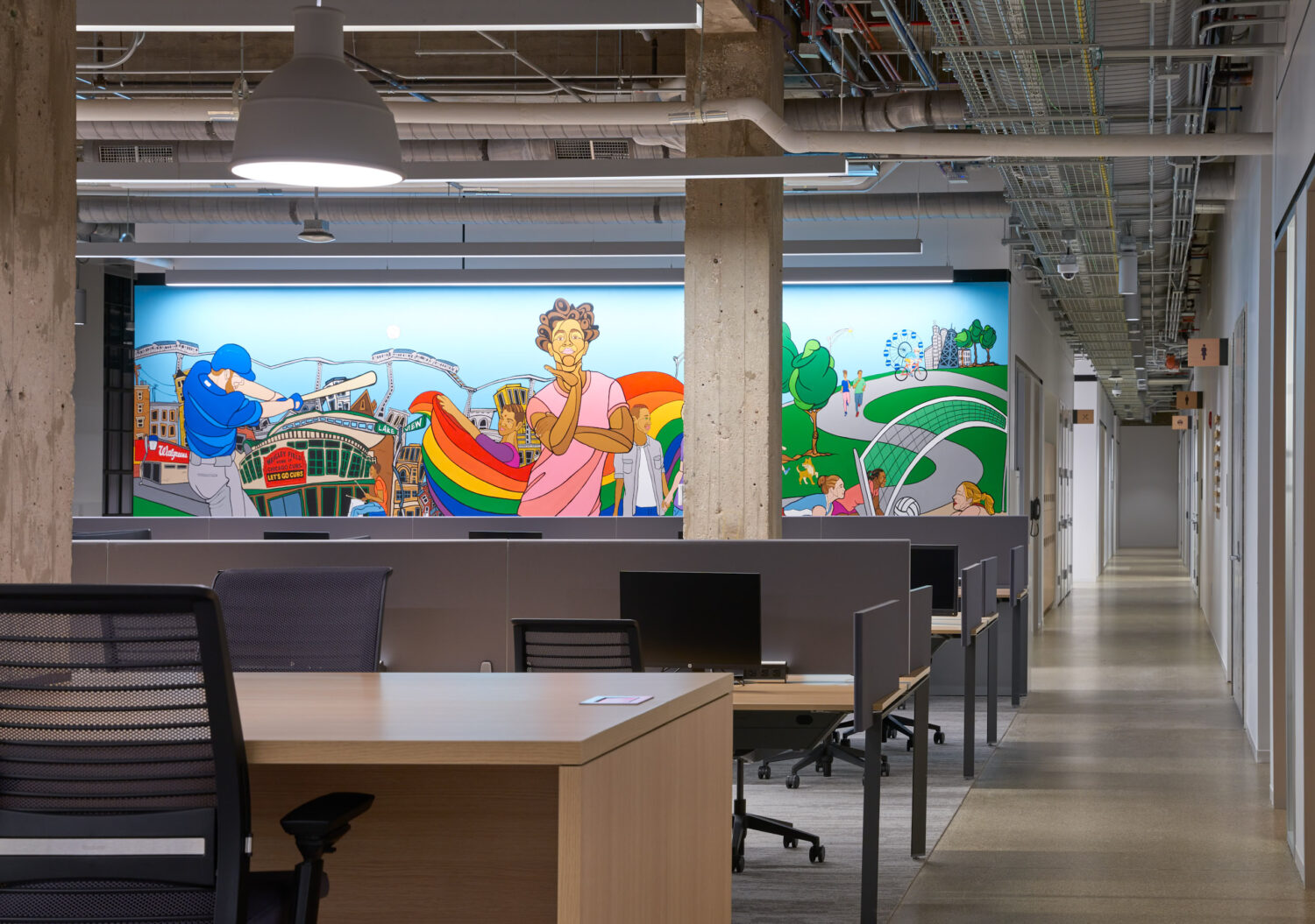 Desks in front of a mural with a baseball player and a rainbow at Walgreens
