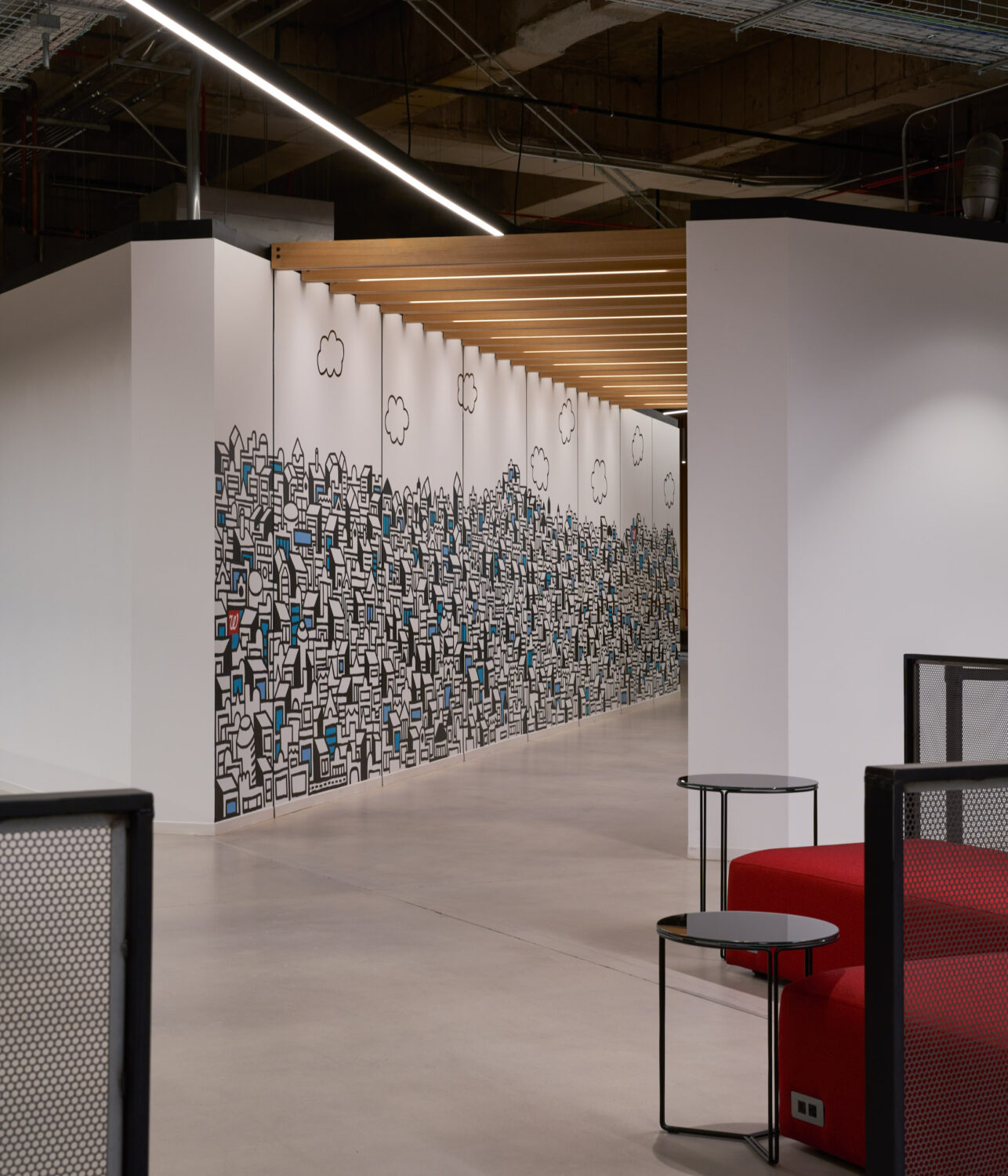 Hand drawn city mural along a corridor with red lounge seating at Walgreens