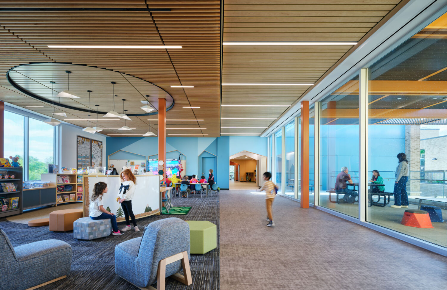 Library and learning commons with soft seating, a round ceiling cloud and glass walls at the Kindergarten Center at Churchill Elementary