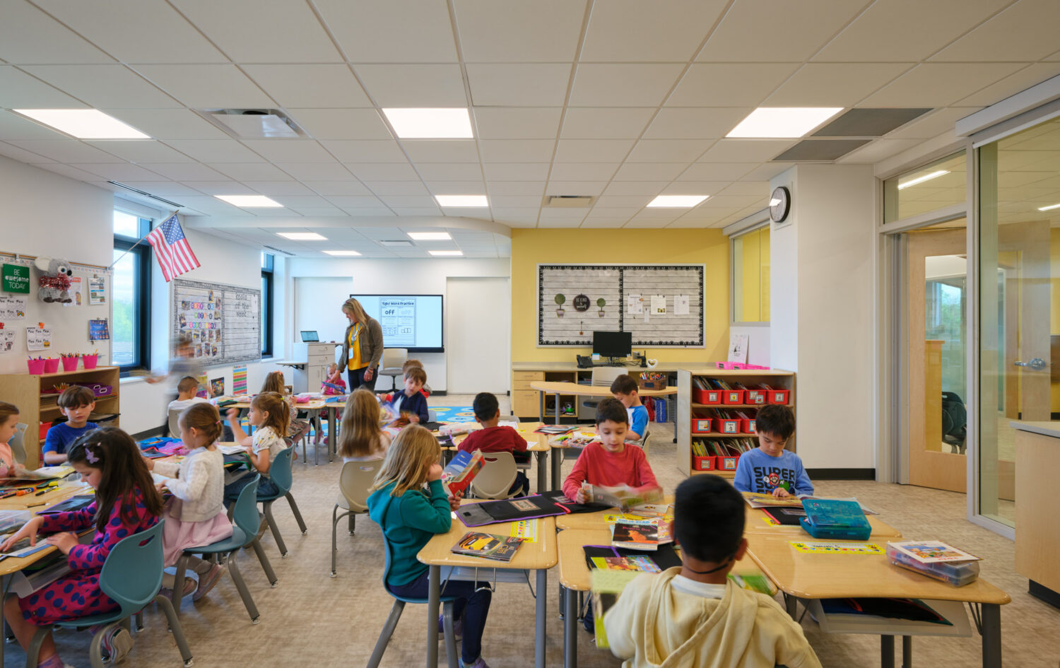 Bright kindergarten classroom full of children working at tables at the Kindergarten Center at Churchill Elementary